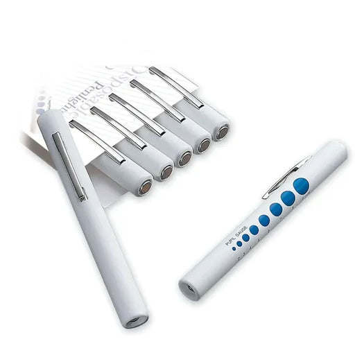 White pupil gauge pens lay on a white background; one pen is angled, displaying a pupil gauge. Five additional pens are shown in a package. PUPIL GAUGE is printed on one pen.