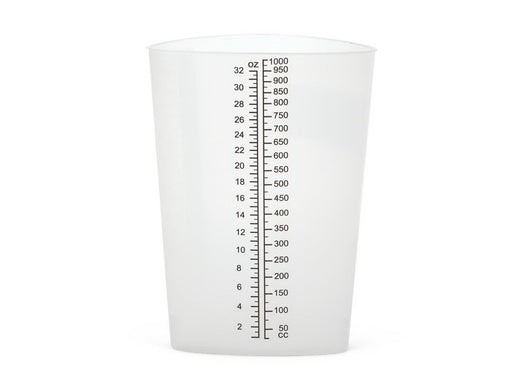 A cylindrical plastic measuring cup sits on a plain white background. It is transparent and features a vertical scale printed on its side for measuring volume.