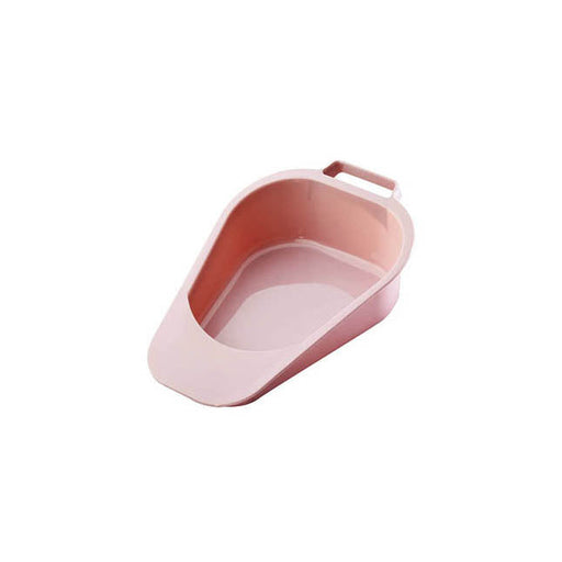 A pink, plastic bedpan faces forward, angled slightly upward on a white background. The bedpan has a handle at the top end.